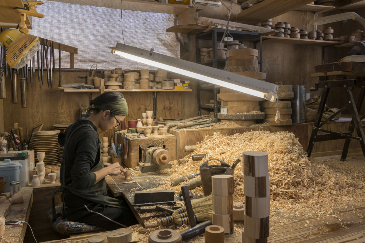 An artisan working on wood bowl in the studio Rokuro-no-Sato and Crafts Hall
